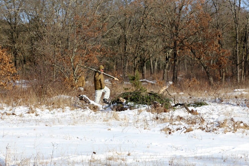 Cold-Weather Operations Course Class 18-04 students build improvised shelters during training at Fort McCoy