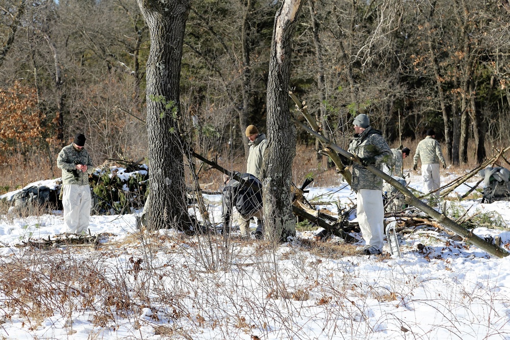 Cold-Weather Operations Course Class 18-04 students build improvised shelters during training at Fort McCoy