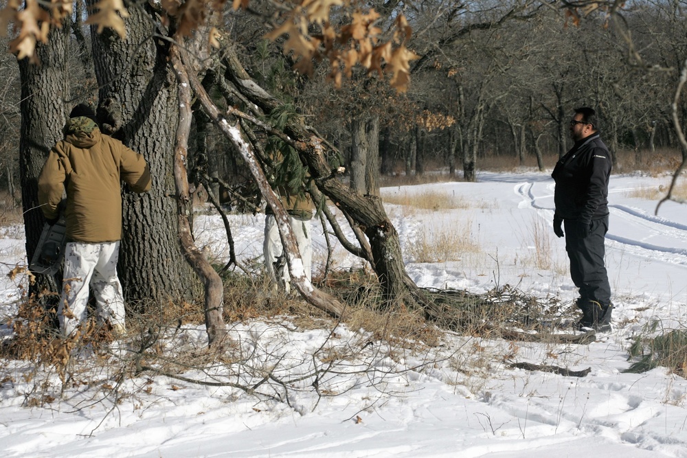 Cold-Weather Operations Course Class 18-04 students build improvised shelters during training at Fort McCoy