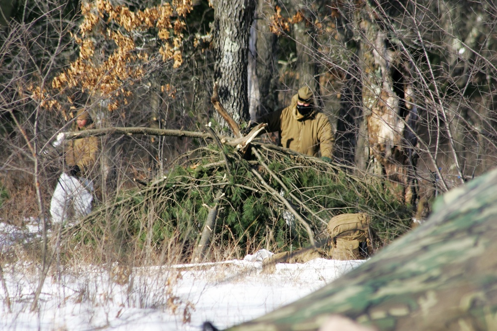 Cold-Weather Operations Course Class 18-04 students build improvised shelters during training at Fort McCoy