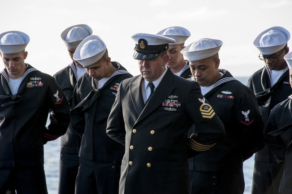 USS America (LHA 6) Sailors bow their heads for chaplain's benediction during a burial at sea ceremony