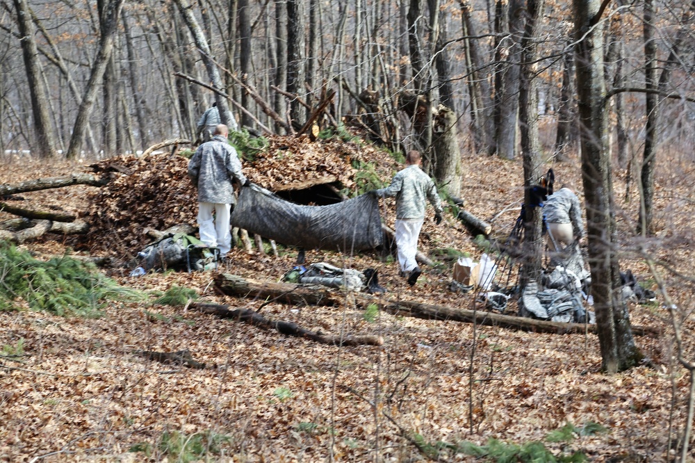 Cold-Weather Operations Course Class 18-05 students build improvised shelters at Fort McCoy