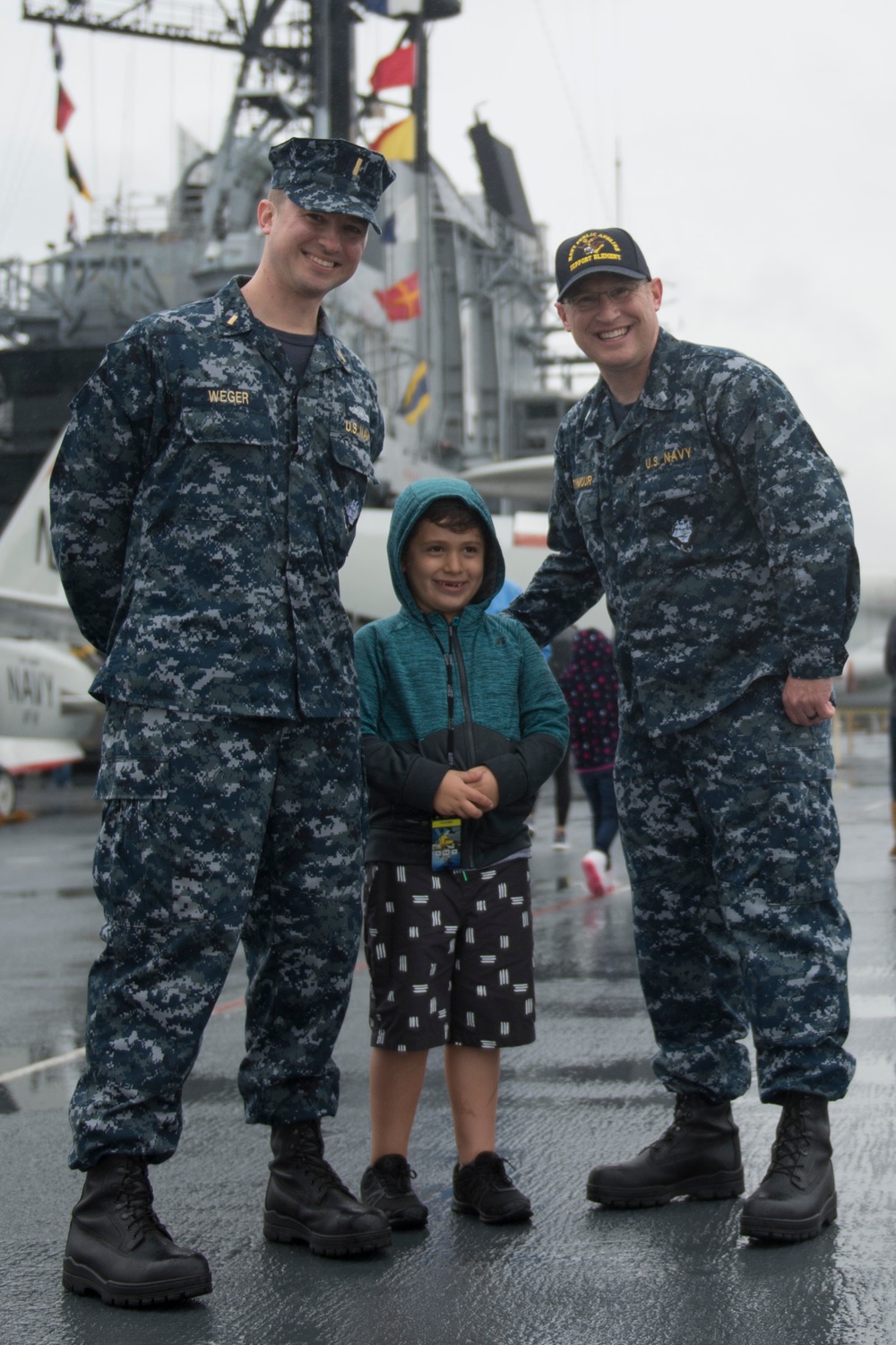 Sailors pose for photo with child