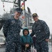 Sailors pose for photo with child