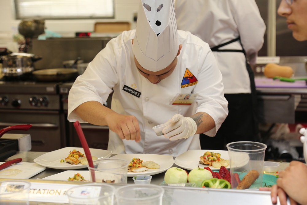 Apprentice Chef Pvt. First Class Kevin Rodriguez First Cavalry Division Culinary Team assists his lead Chef by seasoning preparations