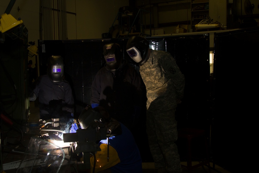 Soldier Observes Students Welding