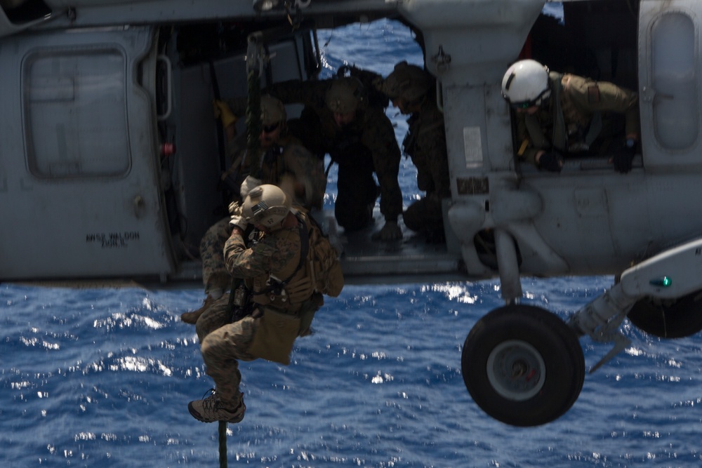 Recon Marines fast rope from an MH-60S aboard the USS Wasp