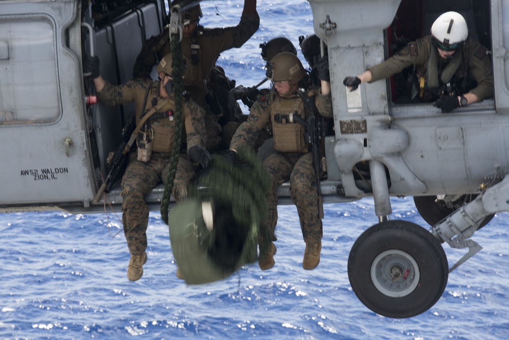 Recon Marines fast rope from an MH-60S aboard the USS Wasp