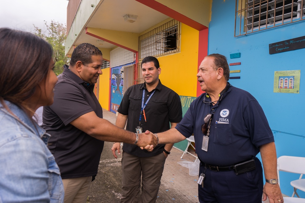 Luis Roberto Clemente is Greeted by FEMA Staff At Event In Lares