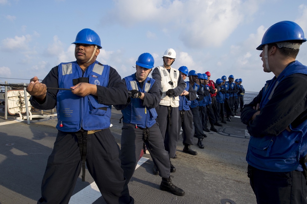 USS Mustin Chief Petty Officers heave a line during a replenishment-at-sea