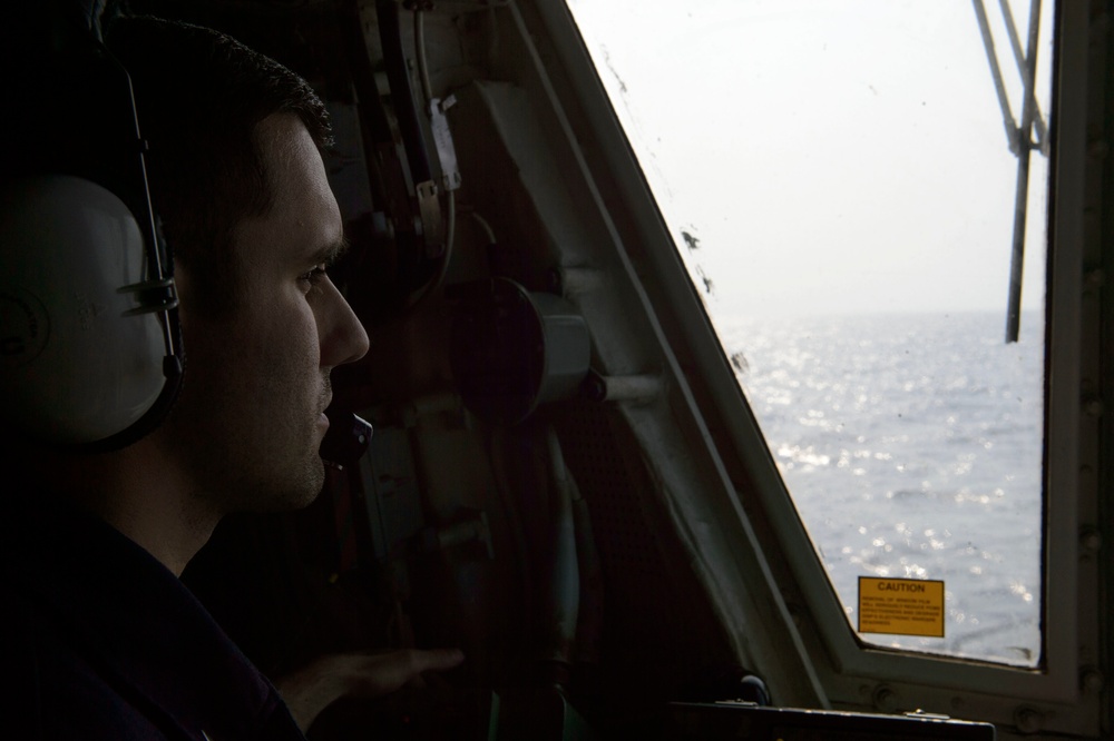 Sailor looks out of flight deck tower on USS Mustin (DDG 89)