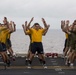 Marines and Sailors PT on the flight deck of the USS Wasp