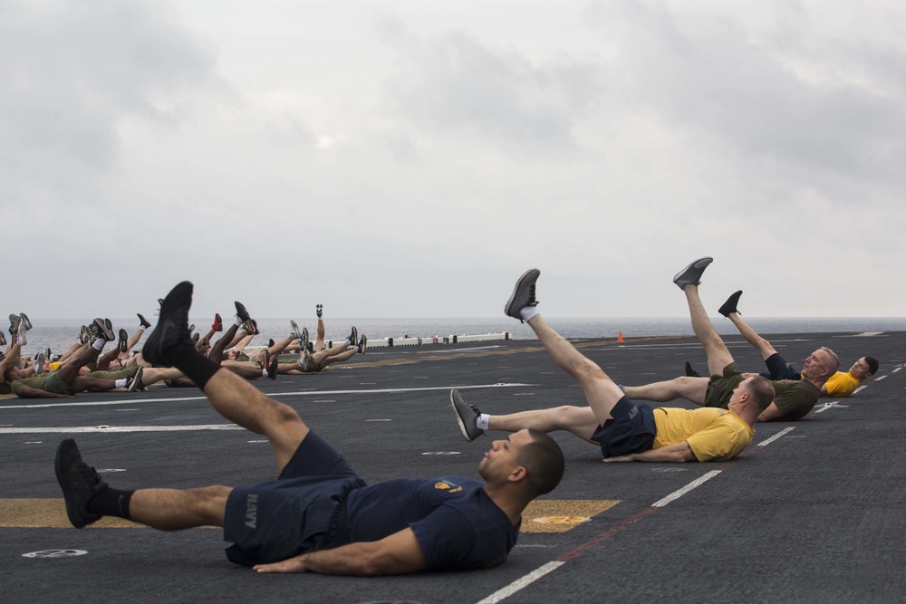 Marines and Sailors PT on the flight deck of the USS Wasp