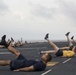 Marines and Sailors PT on the flight deck of the USS Wasp