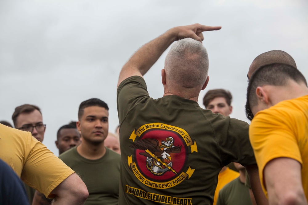 Marines and Sailors PT on the flight deck of the USS Wasp