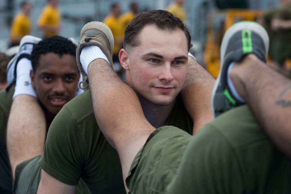 Marines and Sailors PT on the flight deck of the USS Wasp