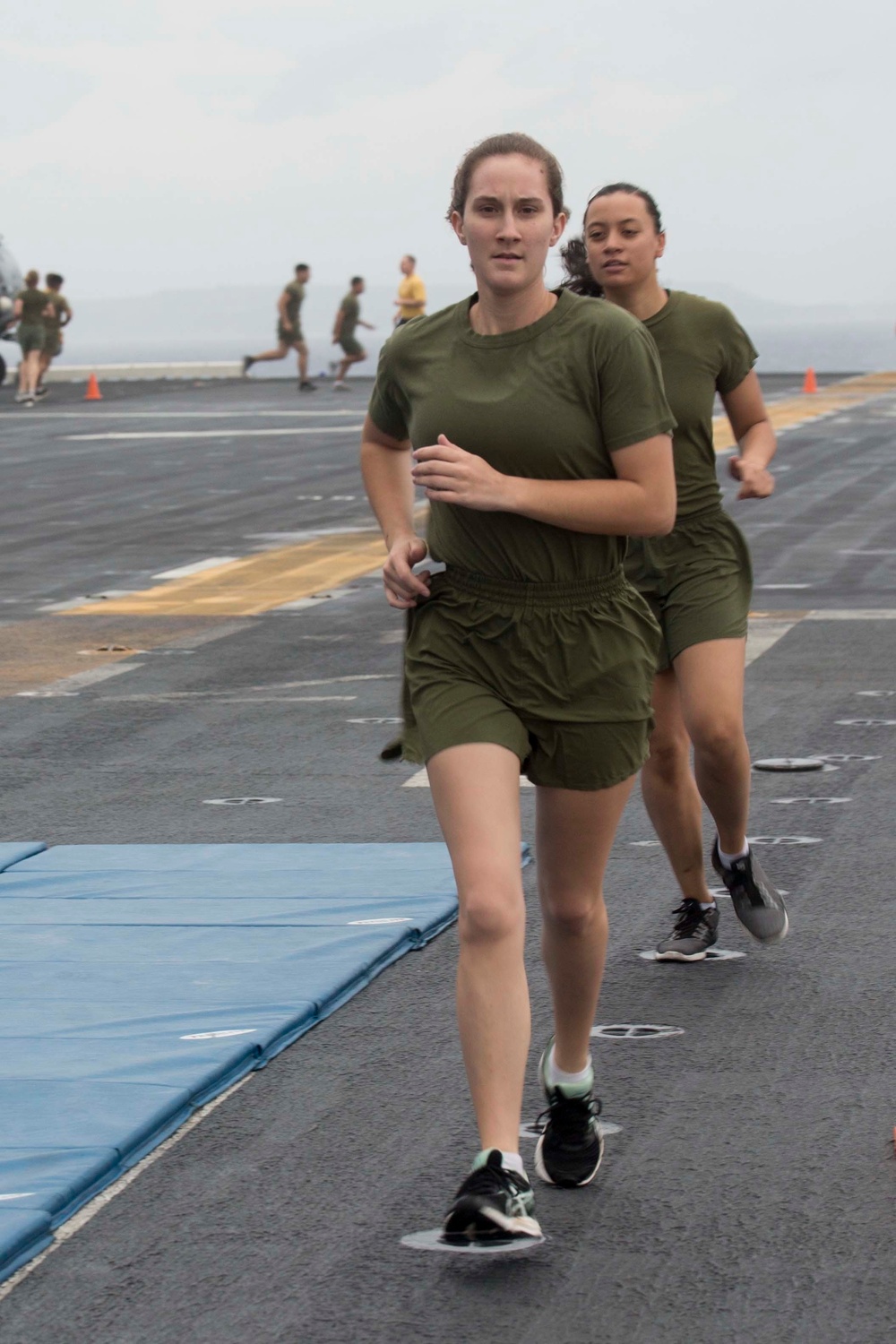 Marines and Sailors PT on the flight deck of the USS Wasp