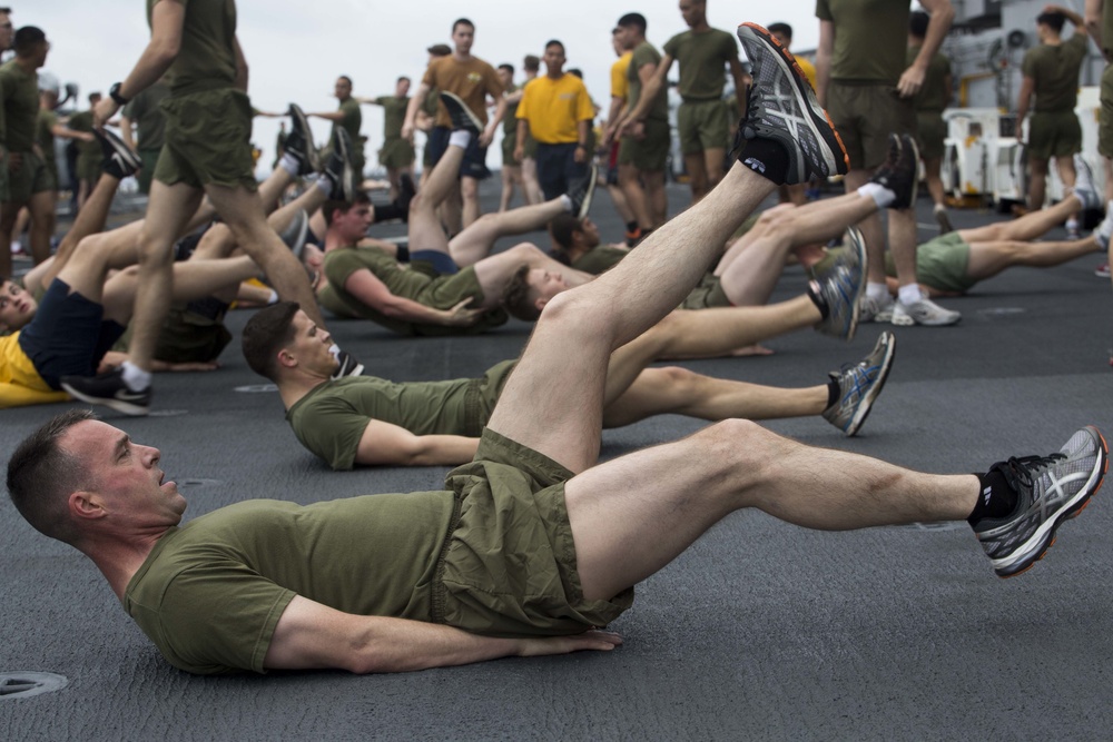 Marines and Sailors PT on the flight deck of the USS Wasp