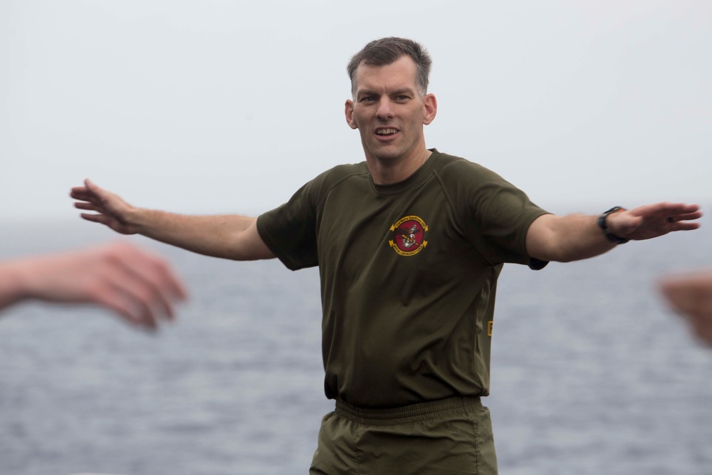 Marines and Sailors PT on the flight deck of the USS Wasp