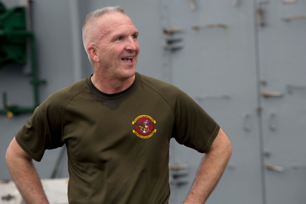 Marines and Sailors PT on the flight deck of the USS Wasp