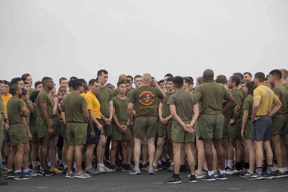 Marines and Sailors PT on the flight deck of the USS Wasp