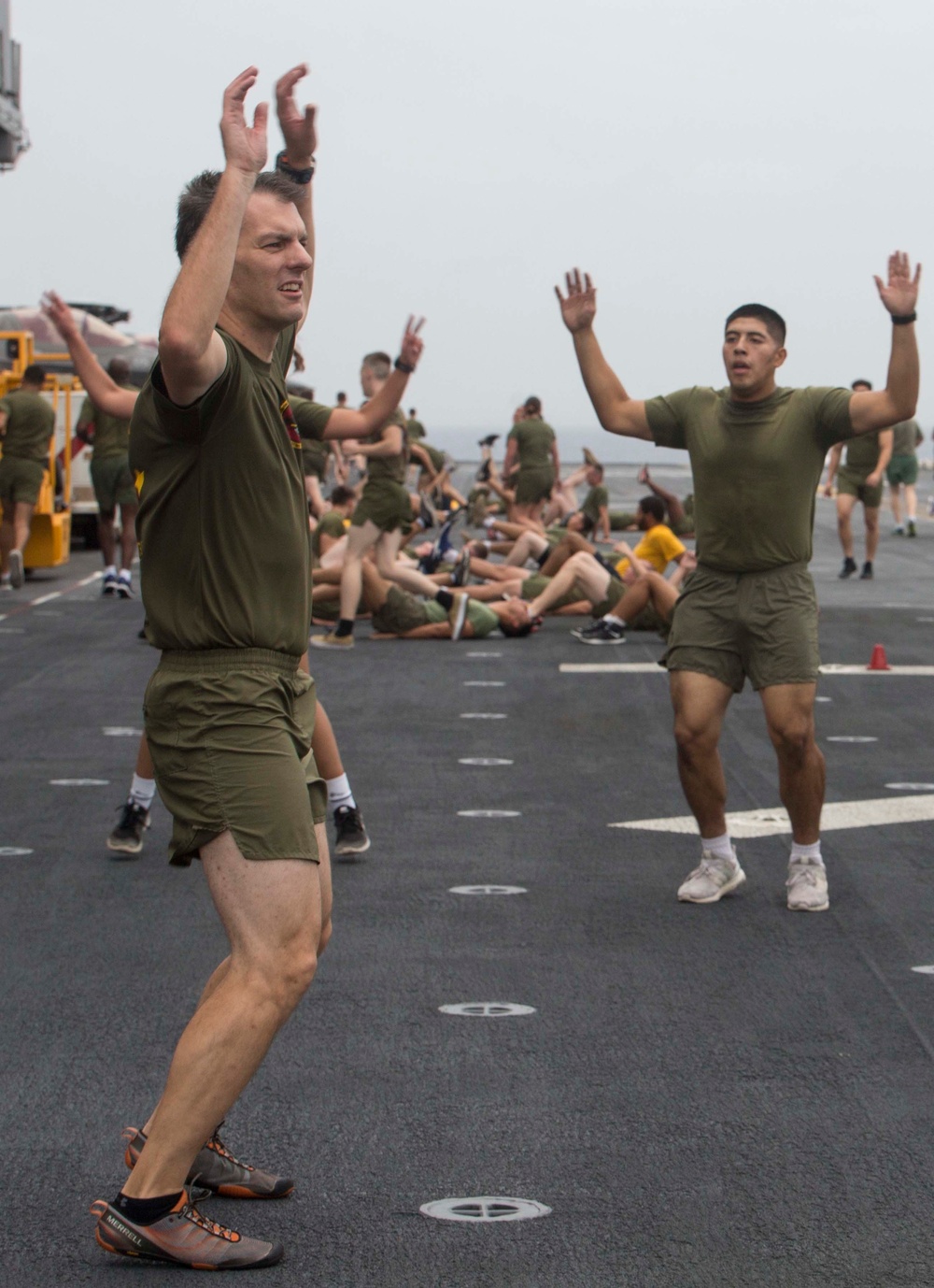 Marines and Sailors PT on the flight deck of the USS Wasp