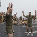 Marines and Sailors PT on the flight deck of the USS Wasp