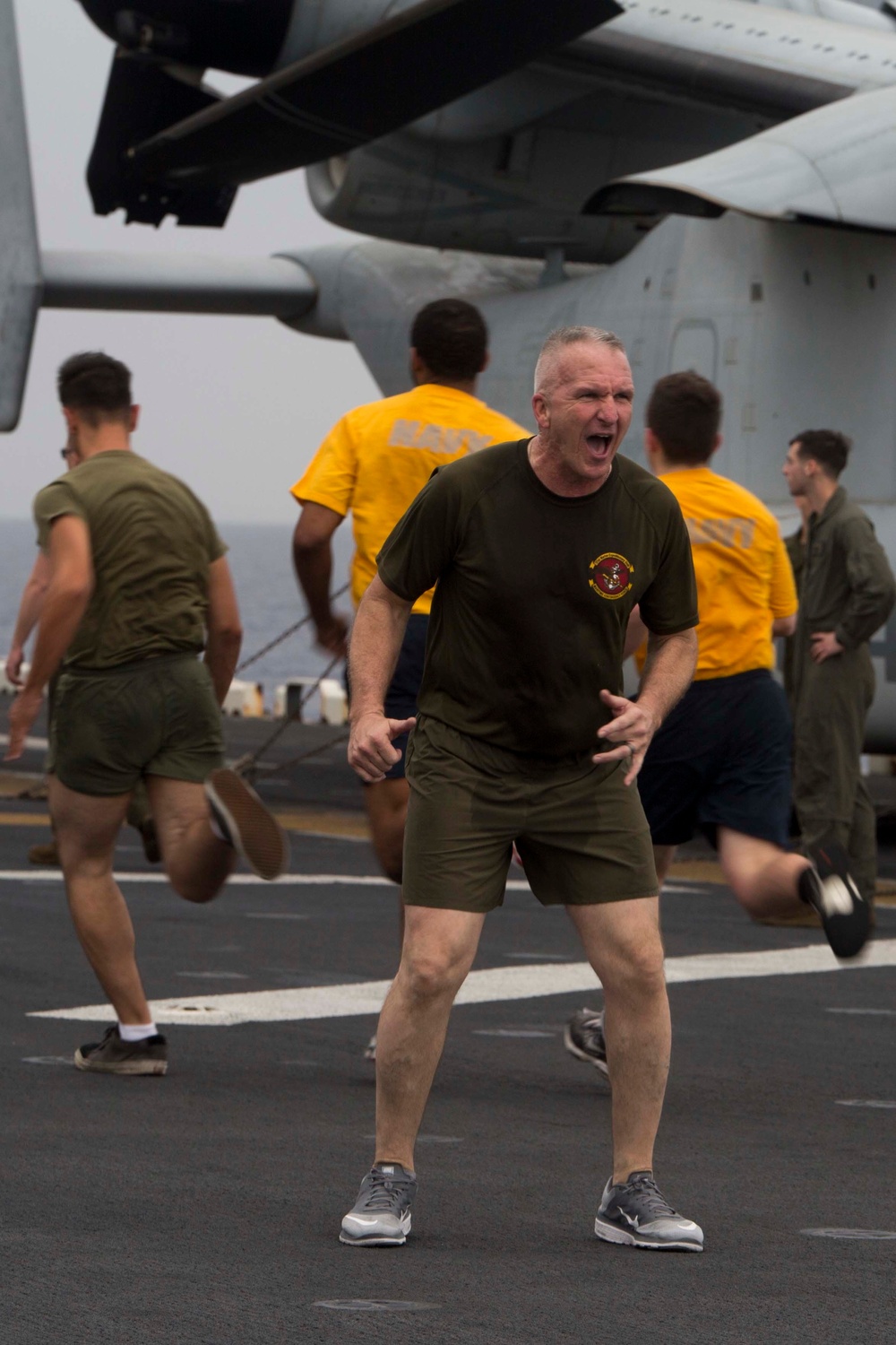 Marines and Sailors PT on the flight deck of the USS Wasp