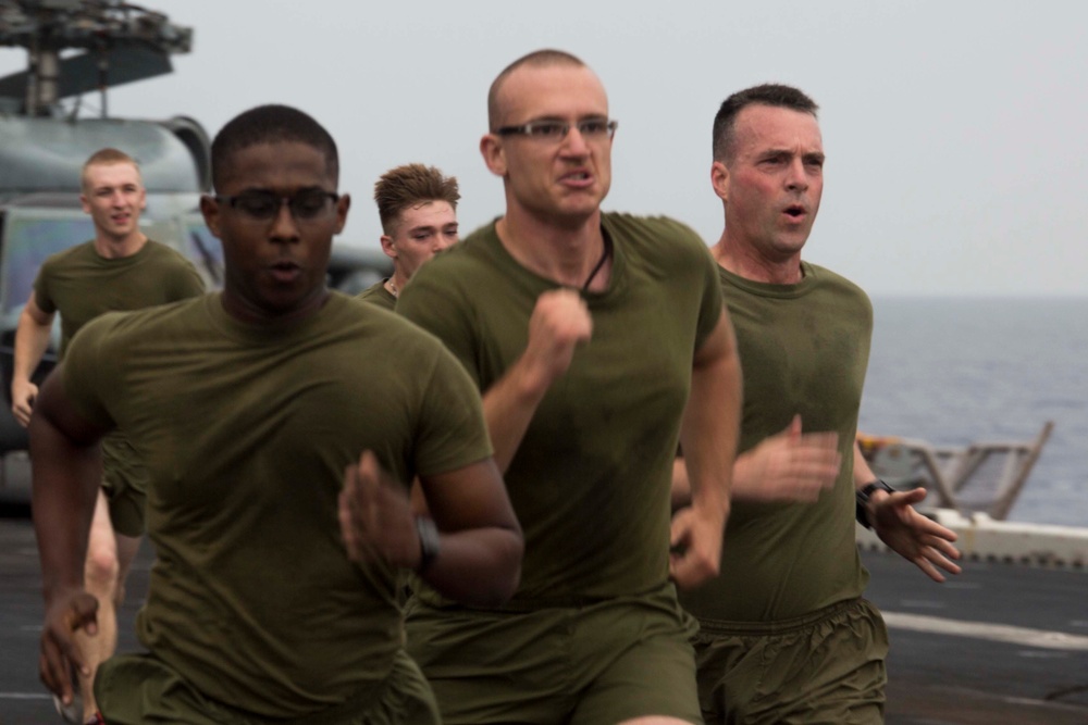 Marines and Sailors PT on the flight deck of the USS Wasp