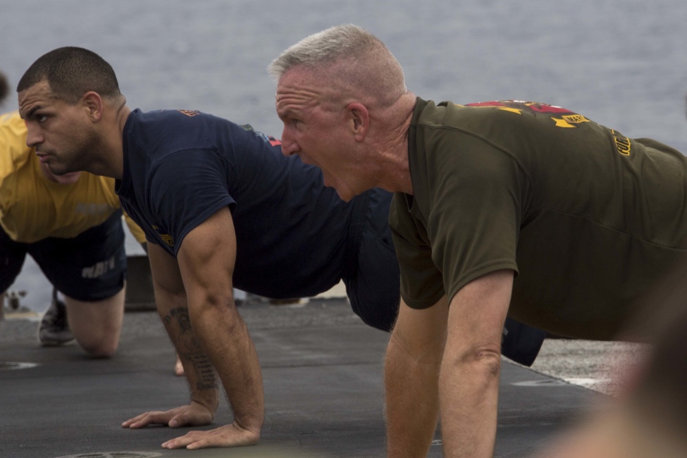 Marines and Sailors PT on the flight deck of the USS Wasp