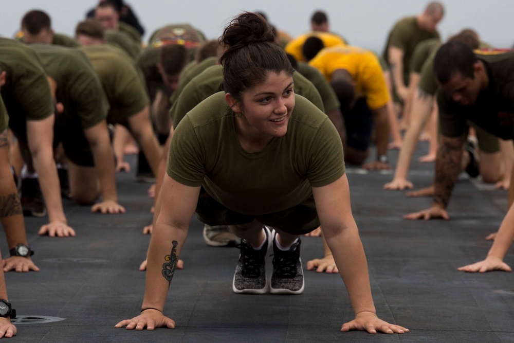 Marines and Sailors PT on the flight deck of the USS Wasp