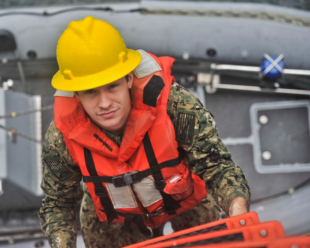 USS Emory S. Land Sailor boards ship after training exercise on a rigid-hull inflatable boat