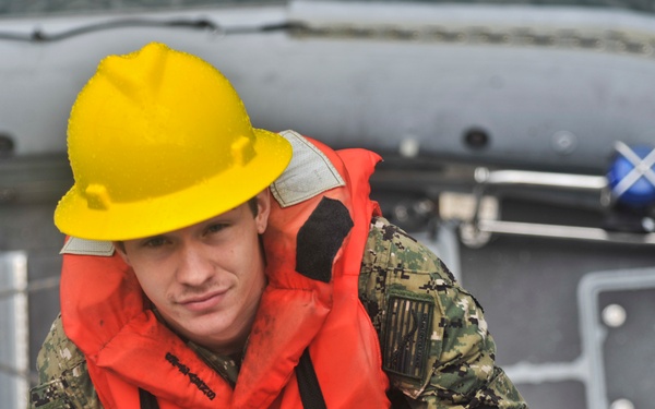 USS Emory S. Land Sailor boards ship after training exercise on a rigid-hull inflatable boat