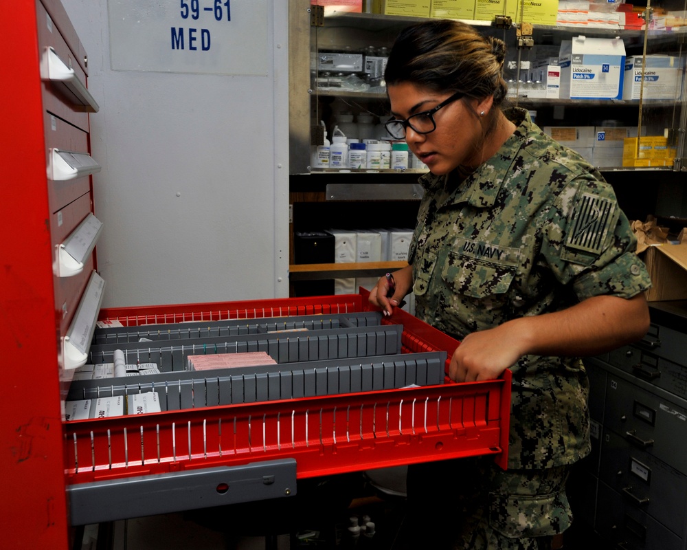 Hospital Corpsman 3rd Class Bryanna Perry searches for supplies in a storeroom during a training evolution in medical department aboard the submarine tender USS Emory S. Land (AS 39)