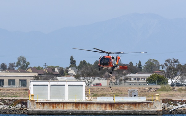 Coast Guard MH-60 helicopter crew transports navigational aid in Seal Beach