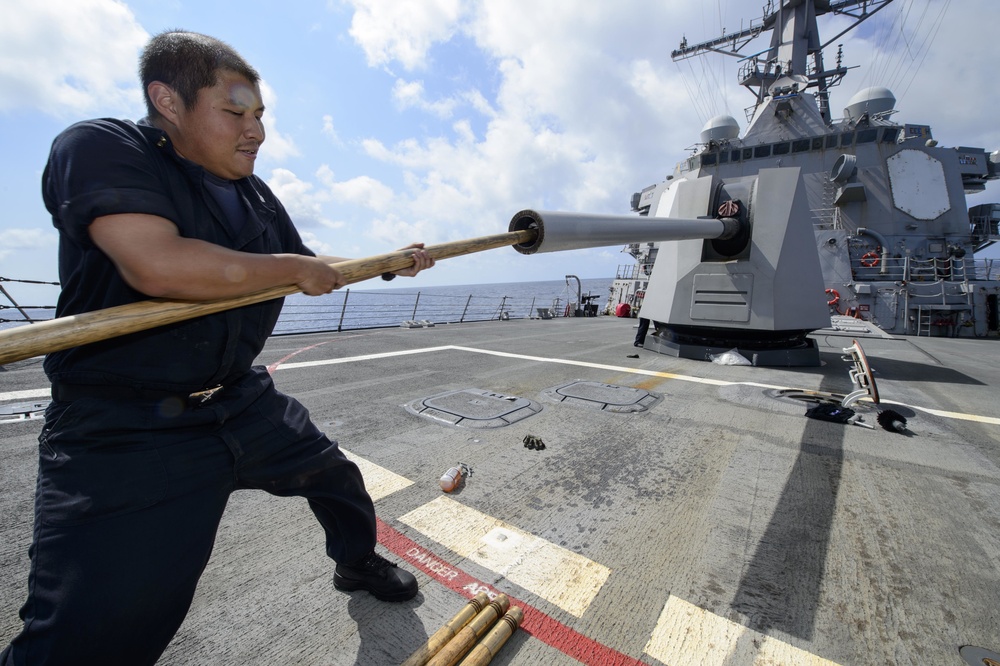 USS Mustin (DDG 89) Sailor performs maintenane on a M160 5-inch gun weapon system