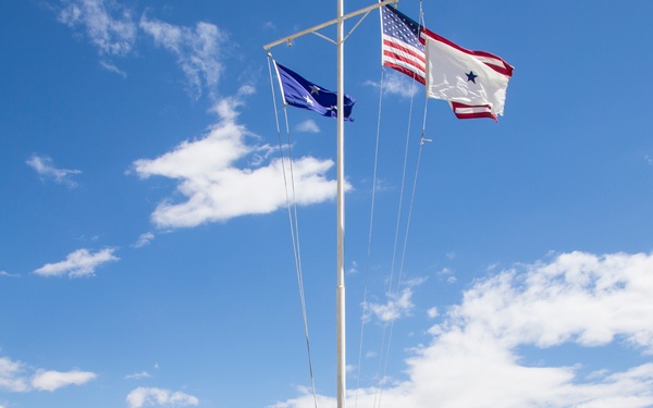 Rear Adm. Scott Dillon watches as his flag is raised