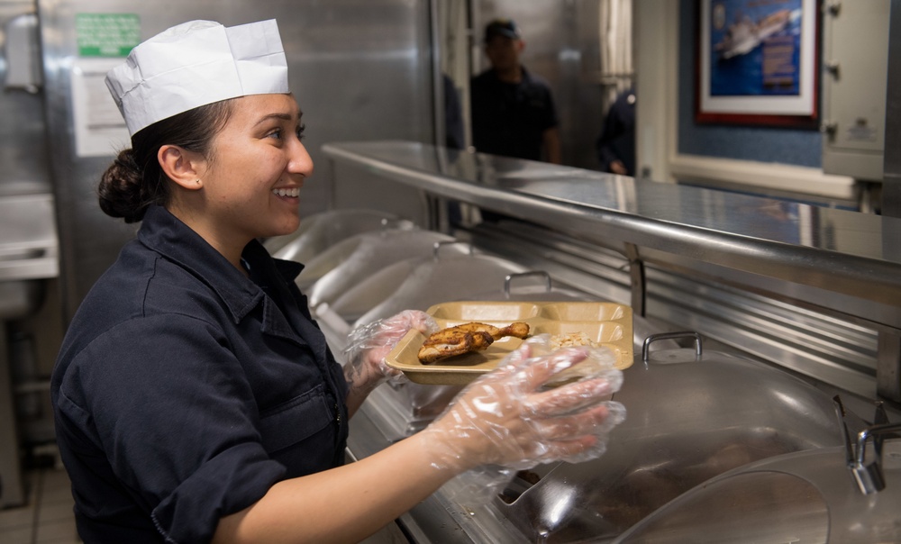 Sailor Serves Food In Galley