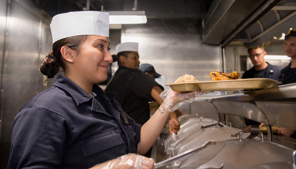 Sailor Serves Food In Galley