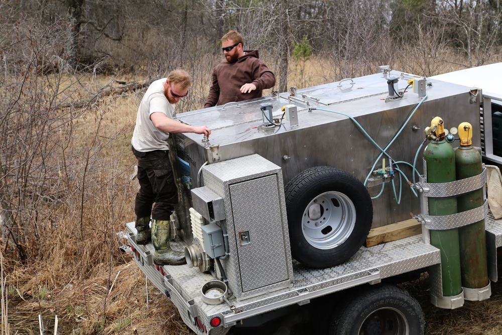U.S. Fish and Wildlife Service personnel stock trout at Fort McCoy lakes