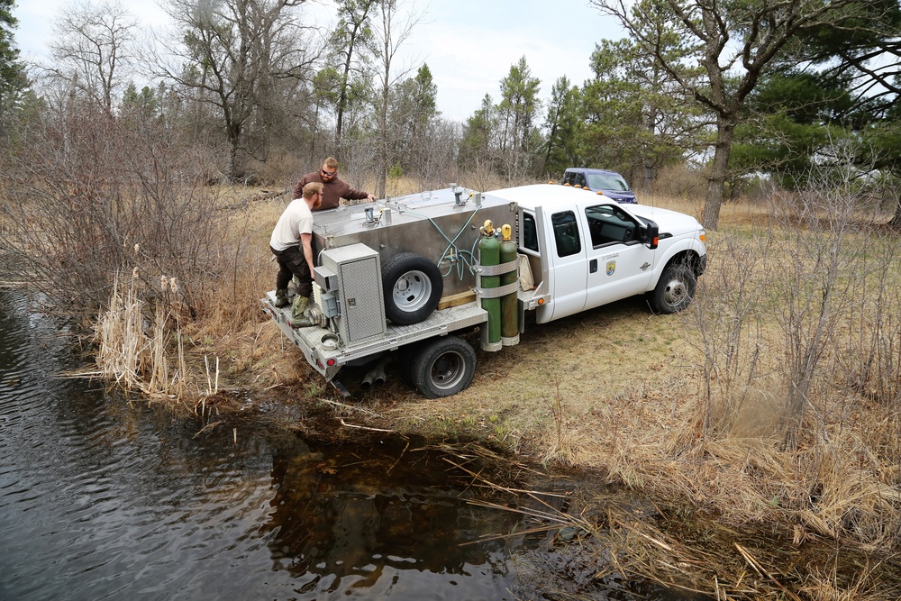 U.S. Fish and Wildlife Service personnel stock trout at Fort McCoy lakes