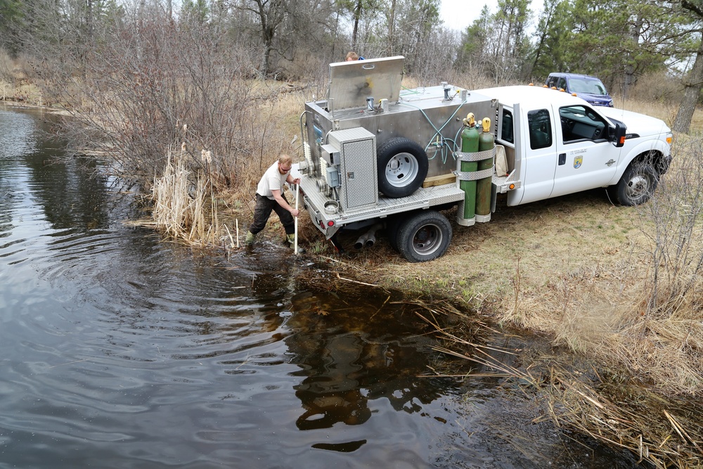 U.S. Fish and Wildlife Service personnel stock trout at Fort McCoy lakes