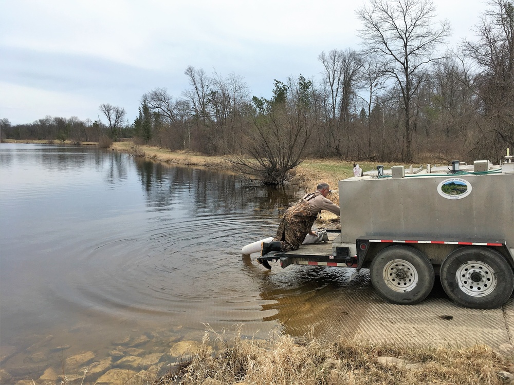 U.S. Fish and Wildlife Service personnel stock trout at Fort McCoy lakes