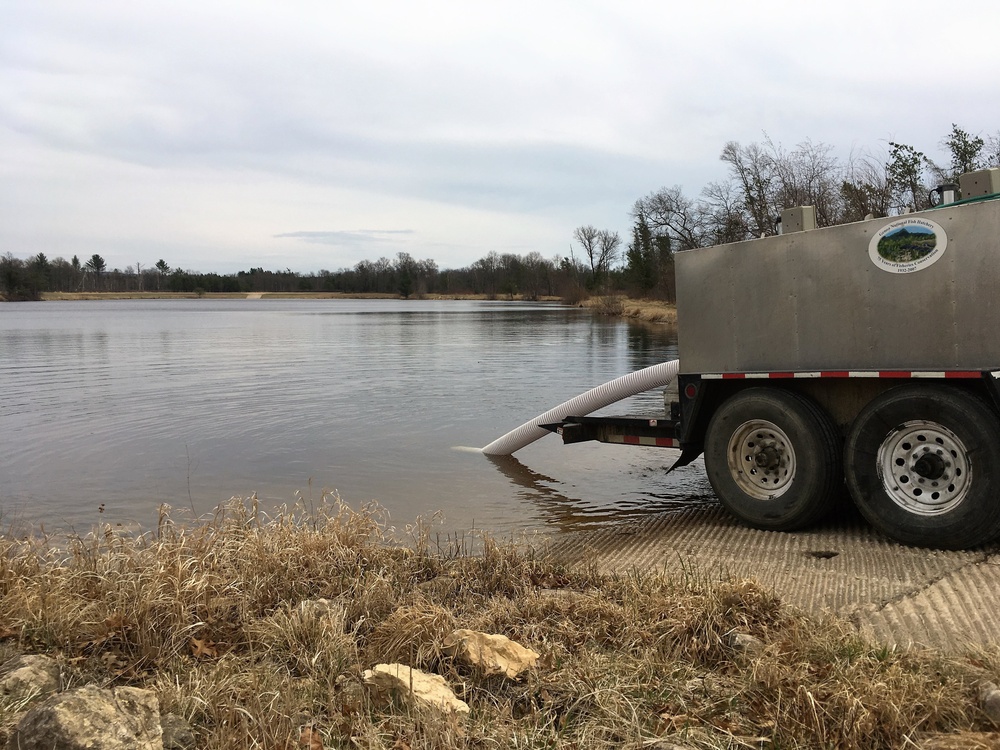 U.S. Fish and Wildlife Service personnel stock trout at Fort McCoy lakes