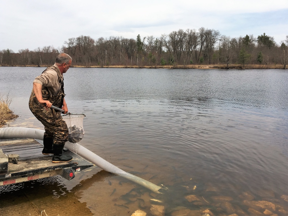 U.S. Fish and Wildlife Service personnel stock trout at Fort McCoy lakes