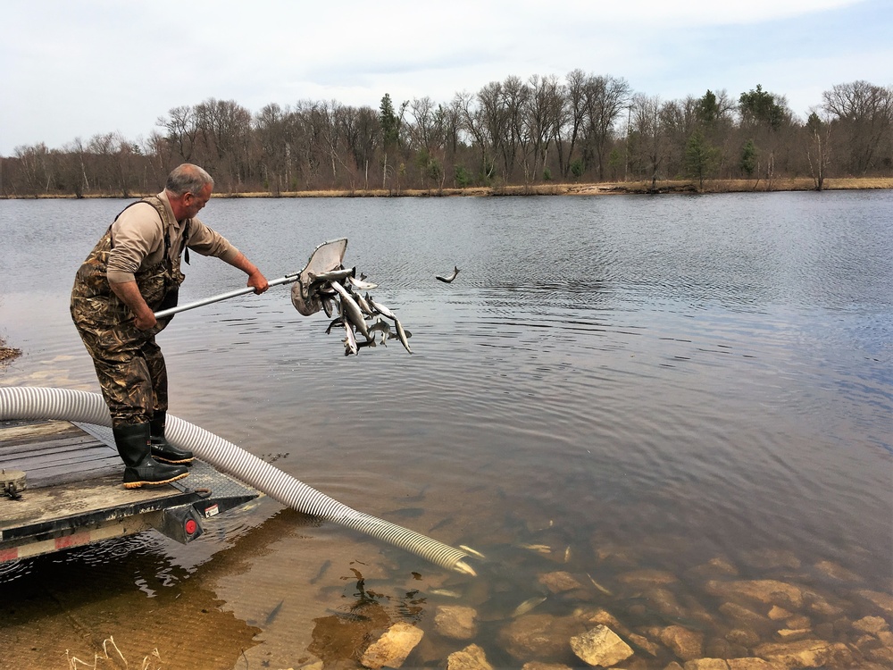 U.S. Fish and Wildlife Service personnel stock trout at Fort McCoy lakes