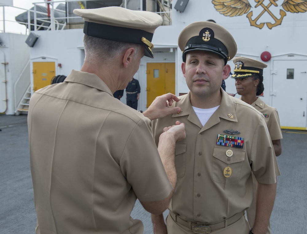 Service members aboard USNS Mercy particpate in a master chief petty officer promotion ceremony