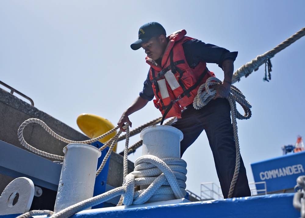 Deck Sailors board a small craft to perform corrosion preventative maintenance on the port side anchor.