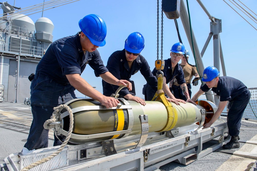 USS Antietam (CG 54) Sailors receive torpedo during ammunition onload