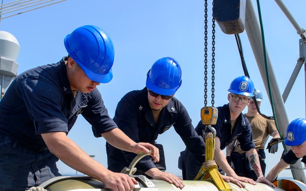 USS Antietam (CG 54) Sailors receive torpedo during ammunition onload